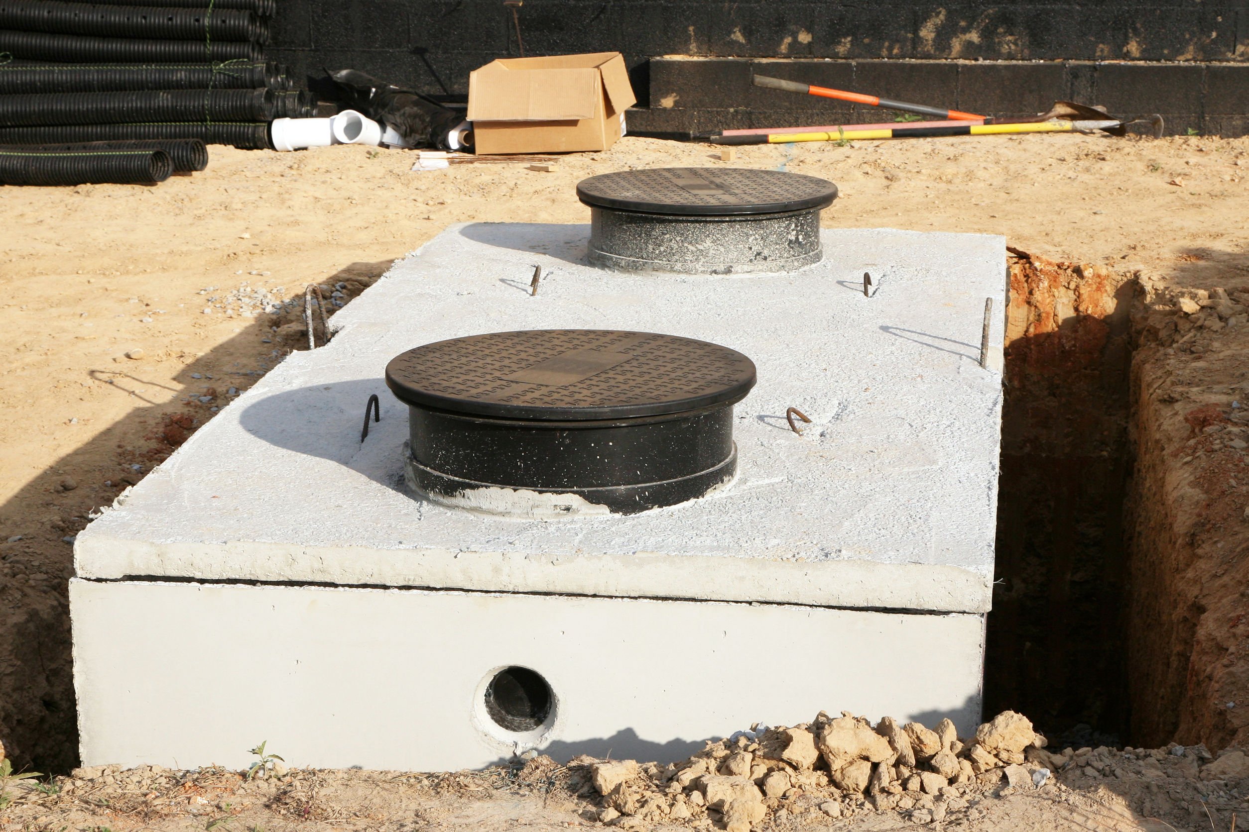 Installation et vidange d'une fosse septique en béton en cours d'installation dans le jardin d'une maison